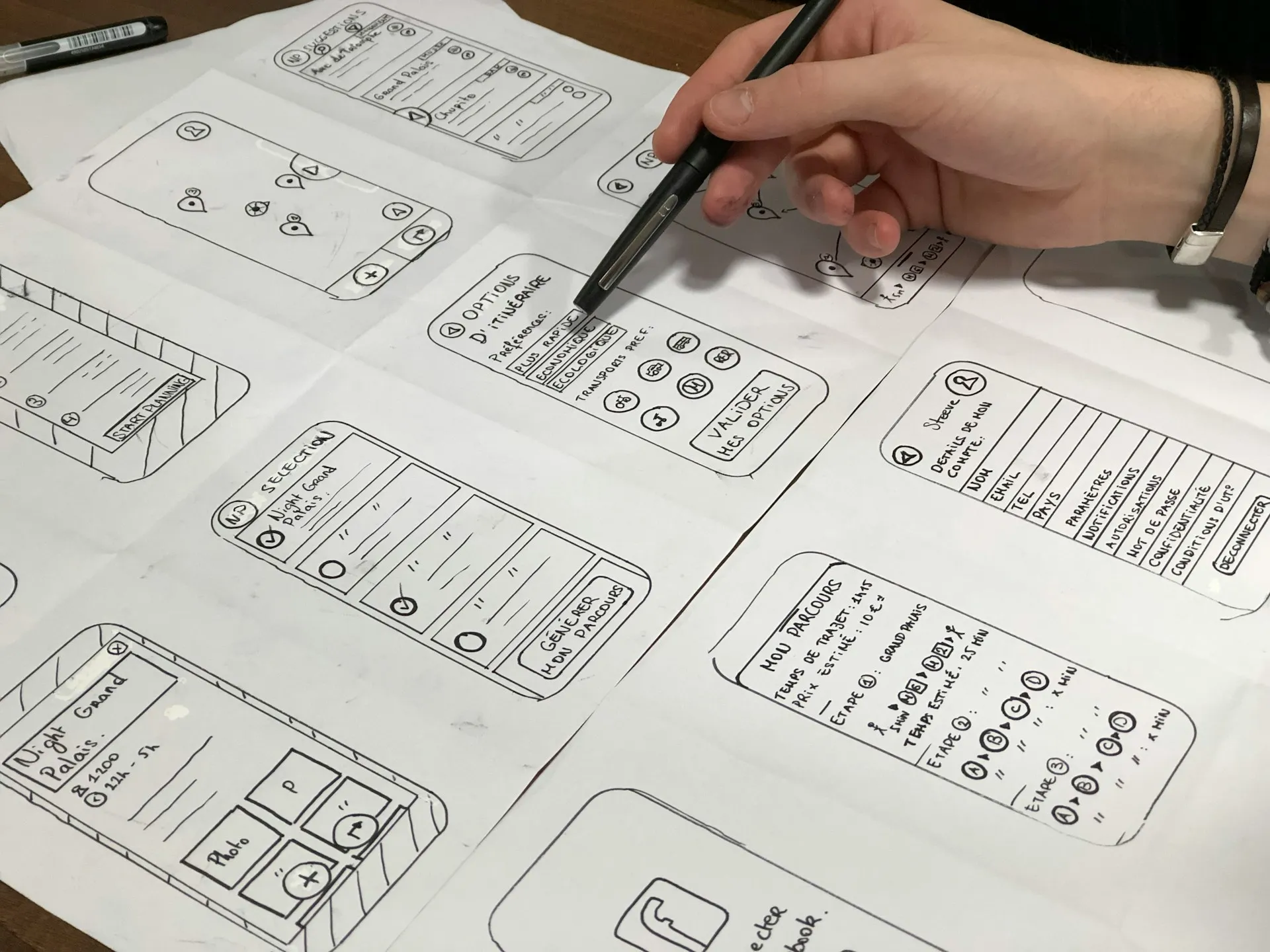 Hand-drawn mobile app wireframes on paper